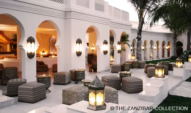 Baraza Resort: weiße orientalische Gebäudeöffnungen und im Vordergrund stimmungsvolle Laternen und Sitzgelegenheiten