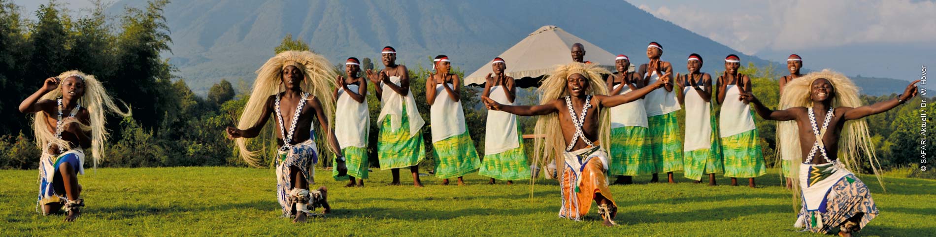 Gruppe afrikanischer Einwohner in farbenfrohen Kleidern tanzen